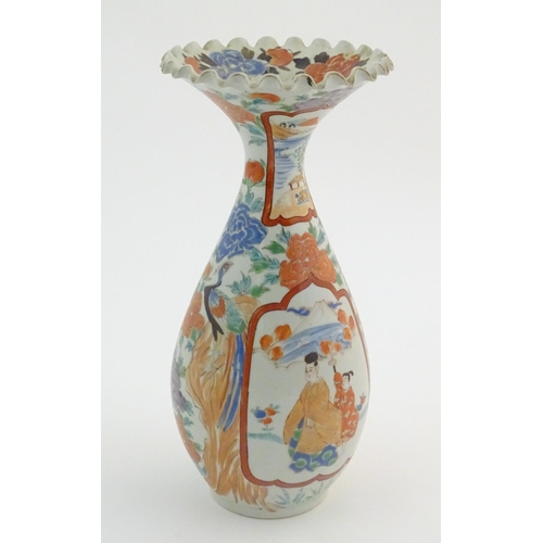 16 - A Japanese vase with a flared rim and scalloped edge, decorated with two figures in a landscape with... 