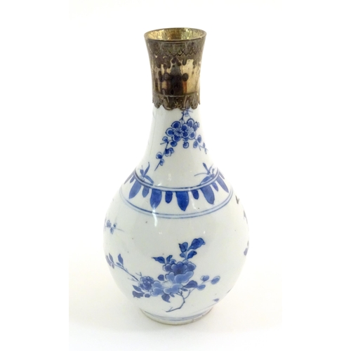 64 - An Oriental blue and white bottle vase with silver plate collar, the body decorated with prunus blos... 