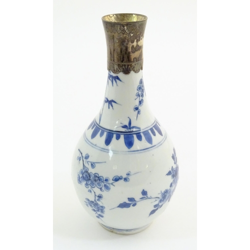 64 - An Oriental blue and white bottle vase with silver plate collar, the body decorated with prunus blos... 