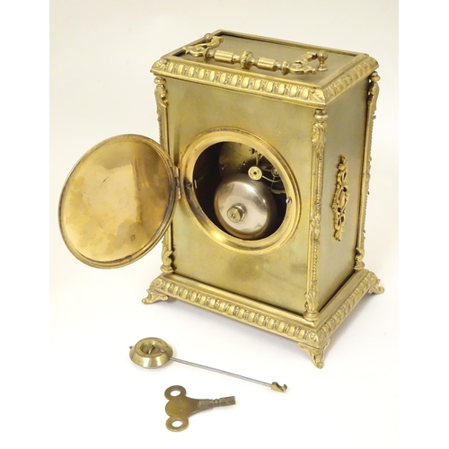 1404 - A late 19thC / early 20thC gilt brass clock with enamel numerals, the 8-day movement striking on a b... 