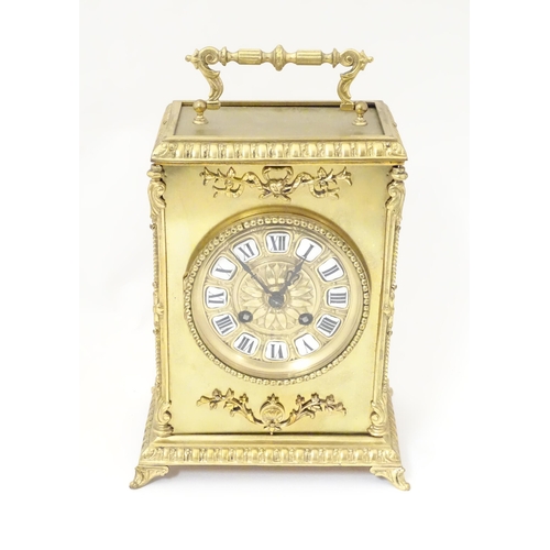 1404 - A late 19thC / early 20thC gilt brass clock with enamel numerals, the 8-day movement striking on a b... 