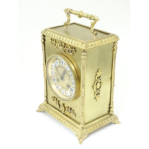 1404 - A late 19thC / early 20thC gilt brass clock with enamel numerals, the 8-day movement striking on a b... 