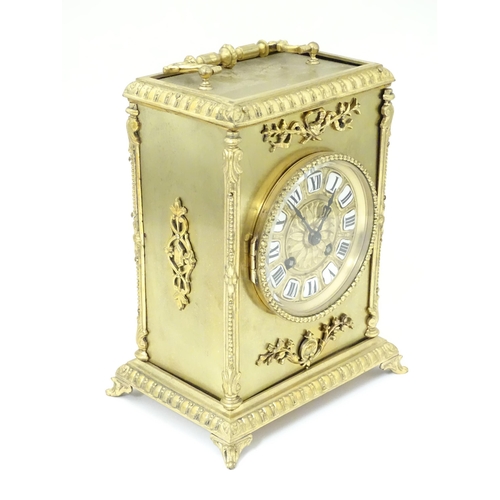 1404 - A late 19thC / early 20thC gilt brass clock with enamel numerals, the 8-day movement striking on a b... 