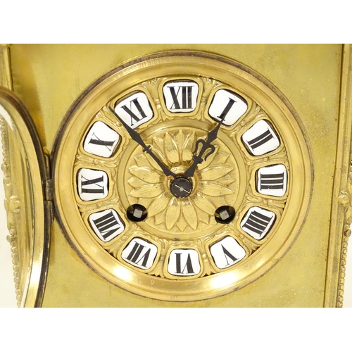 1404 - A late 19thC / early 20thC gilt brass clock with enamel numerals, the 8-day movement striking on a b... 