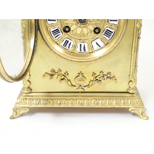 1404 - A late 19thC / early 20thC gilt brass clock with enamel numerals, the 8-day movement striking on a b... 