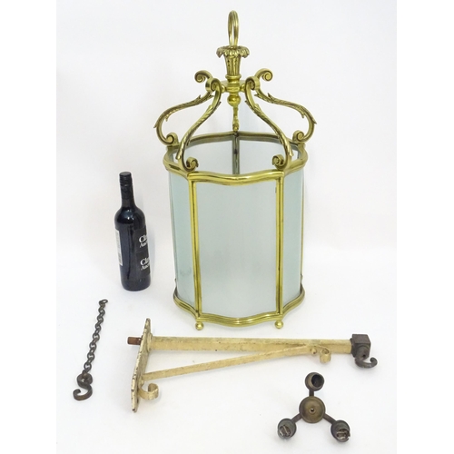 1330 - A 19thC brass hanging lantern and original bracket, the shade with five panels of frosted glass. App... 