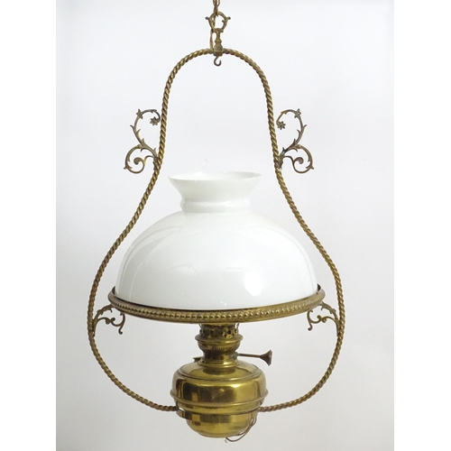 1331 - An early 20thC brass pendant light with white glass shade, the frame decorated with rope twists and ... 