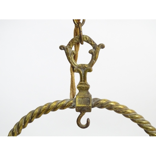 1331 - An early 20thC brass pendant light with white glass shade, the frame decorated with rope twists and ... 