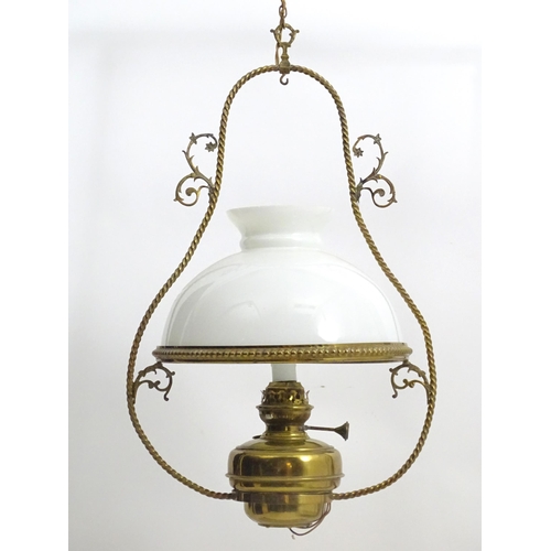 1331 - An early 20thC brass pendant light with white glass shade, the frame decorated with rope twists and ... 