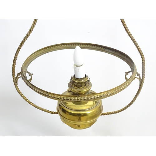 1331 - An early 20thC brass pendant light with white glass shade, the frame decorated with rope twists and ... 