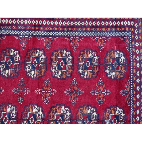 1375 - Carpet / Rug : A Turkoman rug, the red ground with bands of medallions and vignettes Approx. 70 1/2