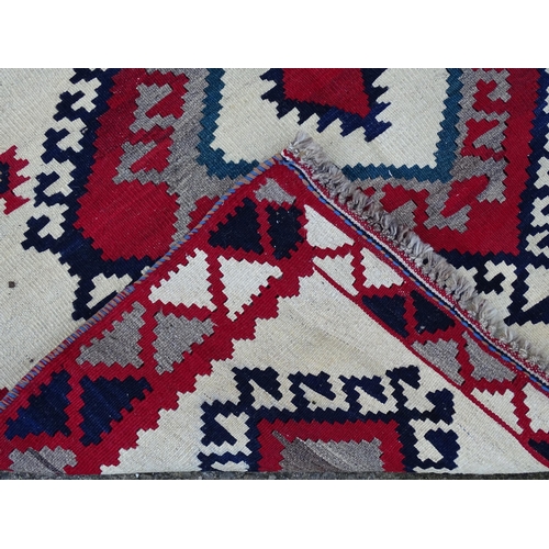 1380 - Carpet / Rug : A Qashqai kilim, the cream ground with red, blue and grey geometric decoration. Appro... 