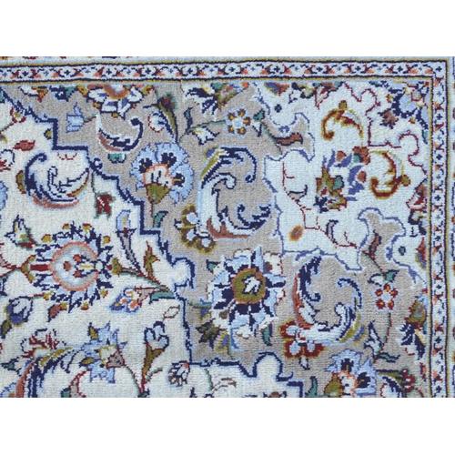 1382 - Carpet / Rug : A Kashan carpet, the cream and beige ground with central medallion and floral and fol... 