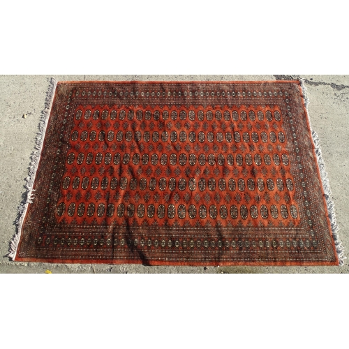 1390 - Carpet / Rug : A red ground rug with banded medallion motifs. Approx. 115