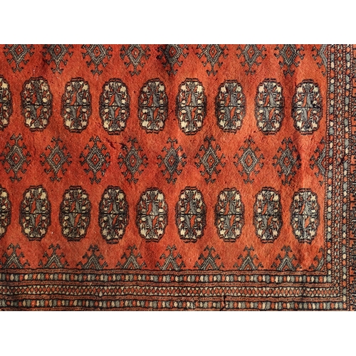 1390 - Carpet / Rug : A red ground rug with banded medallion motifs. Approx. 115