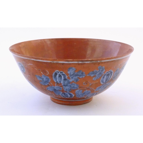 27 - A Chinese bowl with a red ground decorated with vine leaves and gourds. Character marks under. Appro... 