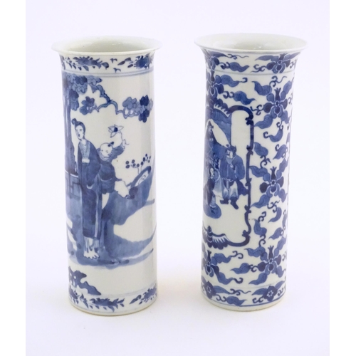 32 - Two Oriental blue and white vases of cylindrical form, one depicting figures in a garden scene with ... 