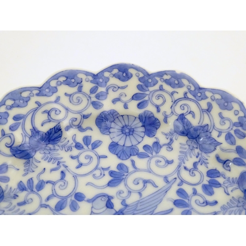 41 - An Oriental blue and white plate with scalloped edge decorated with a stylised exotic pheasant bird ... 