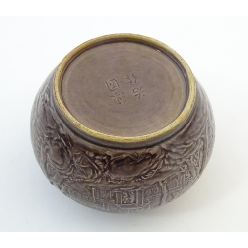6 - A small Chinese pot of squat form with cast landscape detail. Character marks under. Approx. 2 1/8
