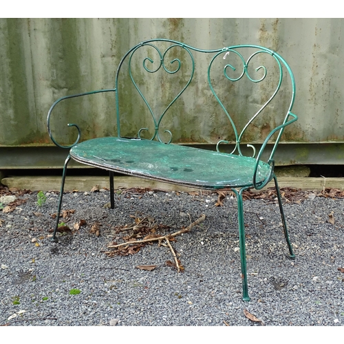 1364 - A two-seater garden bench, of wrought metal construction with two hearts forming the splat, green pa... 