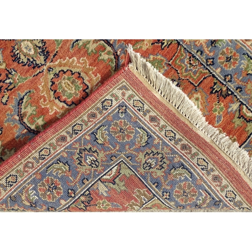 1387 - Carpet / Rug : A runner, the salmon ground with floral and foliate detail and decorative blue and cr... 