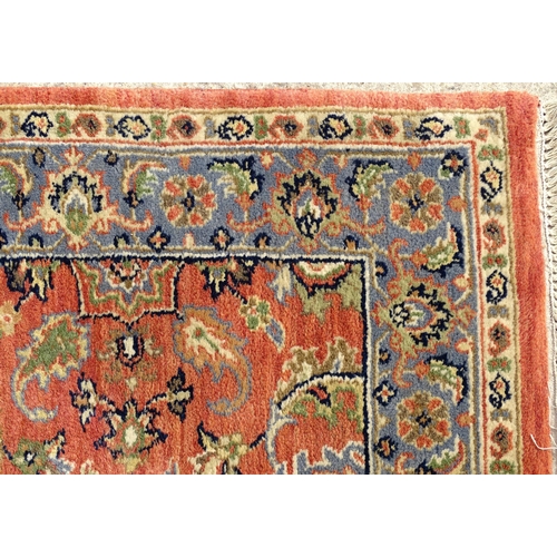 1387 - Carpet / Rug : A runner, the salmon ground with floral and foliate detail and decorative blue and cr... 