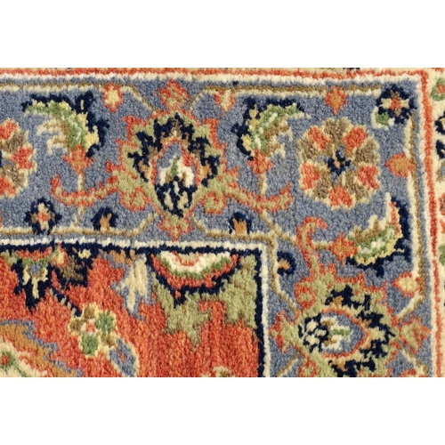 1387 - Carpet / Rug : A runner, the salmon ground with floral and foliate detail and decorative blue and cr... 