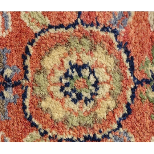 1387 - Carpet / Rug : A runner, the salmon ground with floral and foliate detail and decorative blue and cr... 