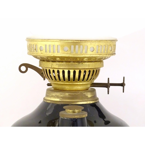 1339 - A Gemfine oil lamp, the black  body decorated with gold banding and white floral vignettes, fitted w... 