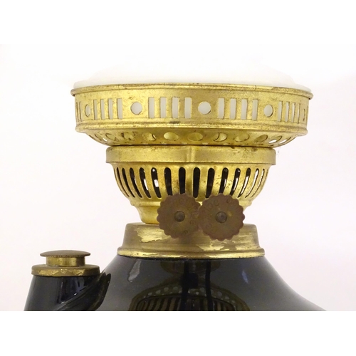 1339 - A Gemfine oil lamp, the black  body decorated with gold banding and white floral vignettes, fitted w... 