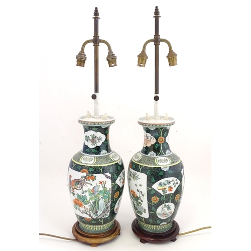 1345 - A pair of late 20thC Chinese ceramic famille verte table lamps with panelled decoration depicting bi... 