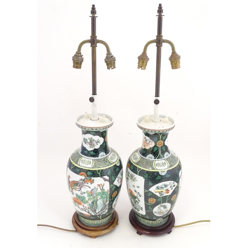 1345 - A pair of late 20thC Chinese ceramic famille verte table lamps with panelled decoration depicting bi... 