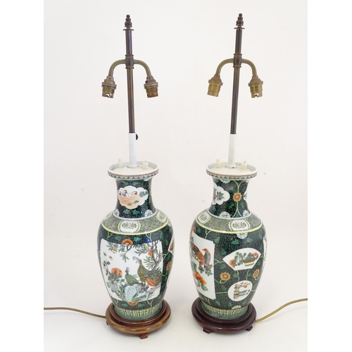 1345 - A pair of late 20thC Chinese ceramic famille verte table lamps with panelled decoration depicting bi... 