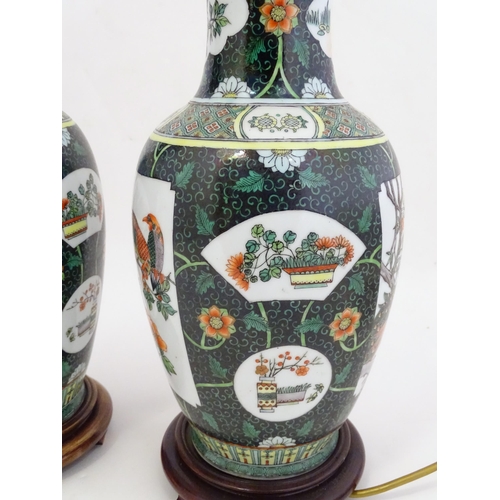 1345 - A pair of late 20thC Chinese ceramic famille verte table lamps with panelled decoration depicting bi... 