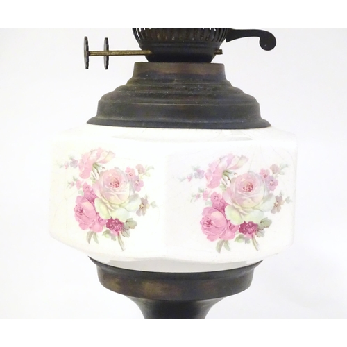 1348 - An early 20thC table oil lamp, the brass column with ceramic mid section decorated with roses and su... 