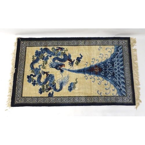 1393 - Carpets / Rugs : An Oriental rug depicting a stylised blue dragon above waves. Approx. 36