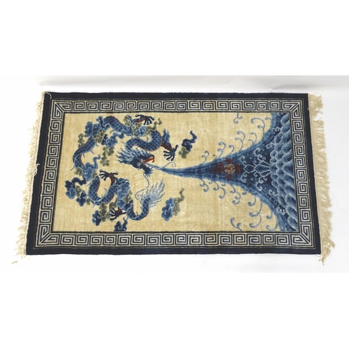 1393 - Carpets / Rugs : An Oriental rug depicting a stylised blue dragon above waves. Approx. 36