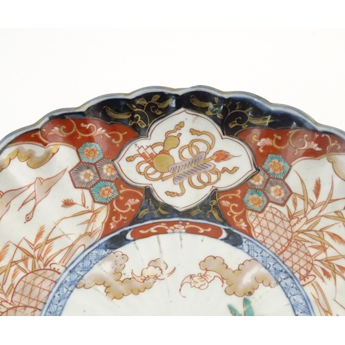 58 - An Oriental charger with scalloped edge in the Imari palette decorated with a stylised censor on sta... 