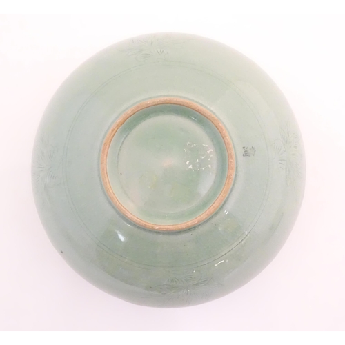 10 - A Chinese celadon style vase of squat form with relief foliate decoration. Character marks to base. ... 