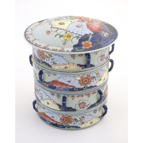 7 - A Chinese four tier lidded porcelain food container of cylindrical form decorated with flowers and f... 