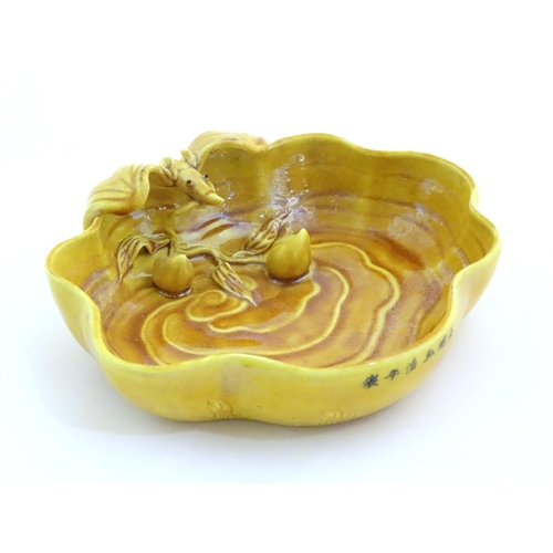 32 - A Chinese fluted edged yellow brush wash dish with relief bat and fruit decoration. Character marks ... 