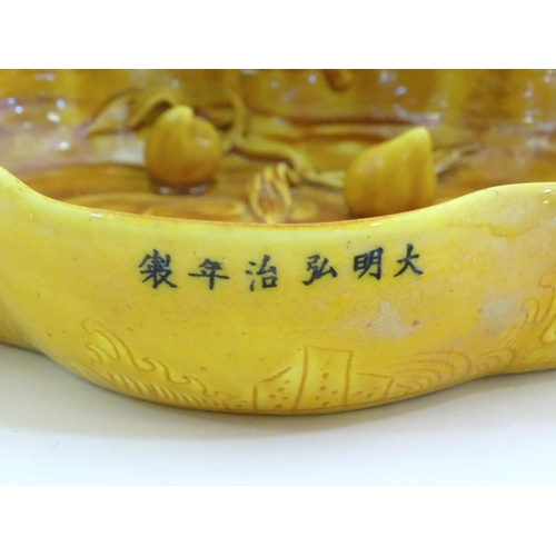 32 - A Chinese fluted edged yellow brush wash dish with relief bat and fruit decoration. Character marks ... 