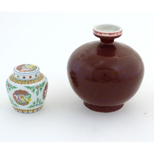 48 - A Chinese sang de boeuf bulbous vase. Character marks under. Together with a Doucai style pot and co... 