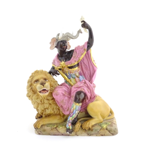 A Meissen allegorical figure group, Allegory of Africa, modelled as a black African female figure wearing an elephant headdress holding a sheaf of corn, seated on the back of a lion. On a rectangular base. Blue crossed swords mark and incised 689 under. Approx. 11 1/2" high