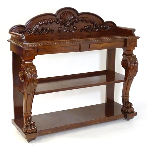 A mid / late 19thC mahogany buffet, bearing makers mark to underside of drawers ‘Rivett & Sons, Makers, Crown St, Finsbury, London’, having  a shaped moulded upstand with heavily carved motifs including , shells, foliage and fruits, the upstand flanked by two scrolled mouldings with carved rosettes. The inverted breakfront having a gadrooned edge above two cushion drawers. Having heavily carved front supports with acanthus carved legs terminating in lions paw feet and raised on brass castors. 60" wide x 21" deep x 57" high.
