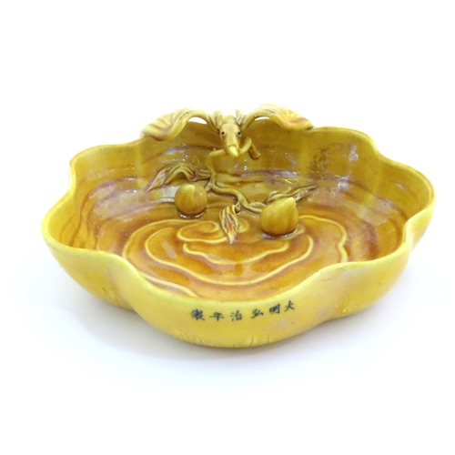 18 - A Chinese fluted edged yellow brush wash dish with relief bat and fruit decoration. Character marks ... 