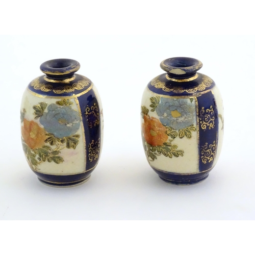 33 - A pair of small Japanese vases decorated with flowers and foliage with gilt highlights. Character ma... 