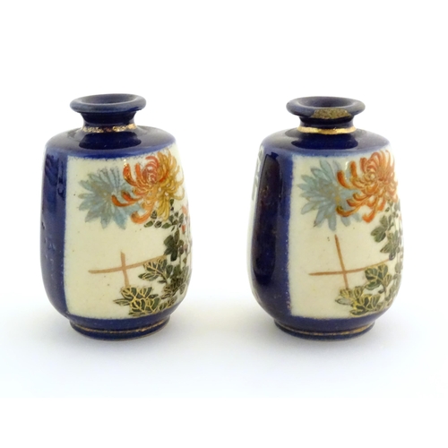 36 - A pair of small Japanese vases decorated with chrysanthemum flowers and foliate detail with gilt hig... 