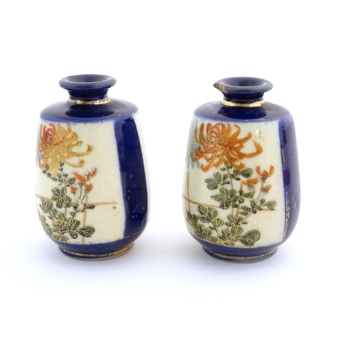 36 - A pair of small Japanese vases decorated with chrysanthemum flowers and foliate detail with gilt hig... 