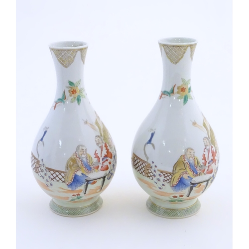 42 - A pair of Chinese famille rose bottle vases decorated with seated figures on a garden terrace, with ... 